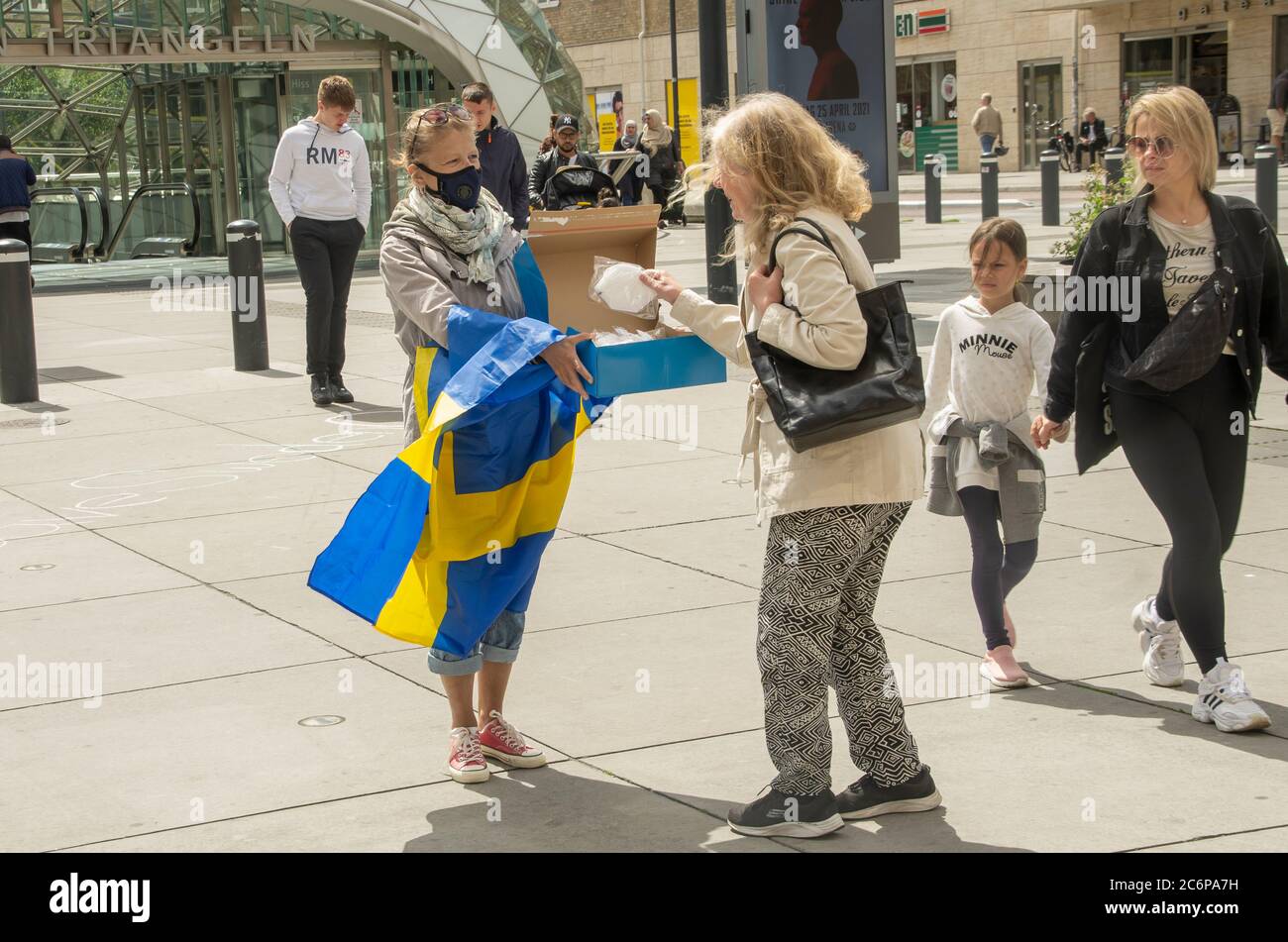 Malmö, Schweden. Juli 2020. Vor dem Bahnhof Triangeln in Malmö fand ein Protestakt gegen die schwedischen „laxen“ Coronavirus-Maßnahmen statt. Eine kleine Gruppe von Aktivisten zeigte Informationen über die Ausbreitung des Coronavirus im Land und ermutigte die Menschen, Gesichtsmaske zu verwenden, um die Ausbreitung des Virus zu verhindern. Sie gaben den Menschen kostenlose Gesichtsmasken und informierten, dass Schweden der 6. Versuch sei, mit mehr Todesfällen pro Kopf aufgrund von Covid-19. Kredit: Lora Grigorova/Alamy Live Nachrichten Stockfoto