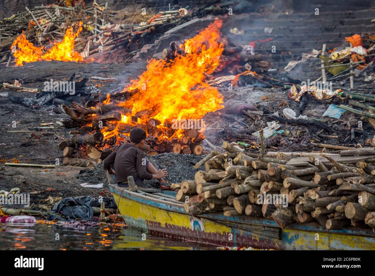 Varanasi brennendes Ghat mit Holzhaufen, Indien. Stockfoto