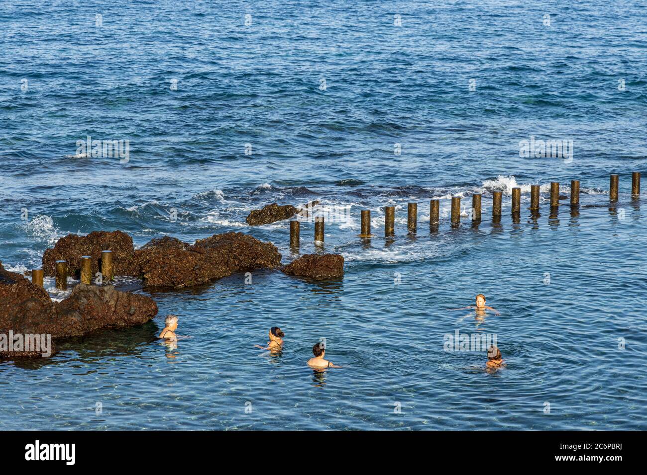 Schwimmer in einem Meerwasser-Schwimmbad in den Felsen an der Küste von La Jaquita, Alcala, Teneriffa, Kanarische Inseln, Spanien Stockfoto