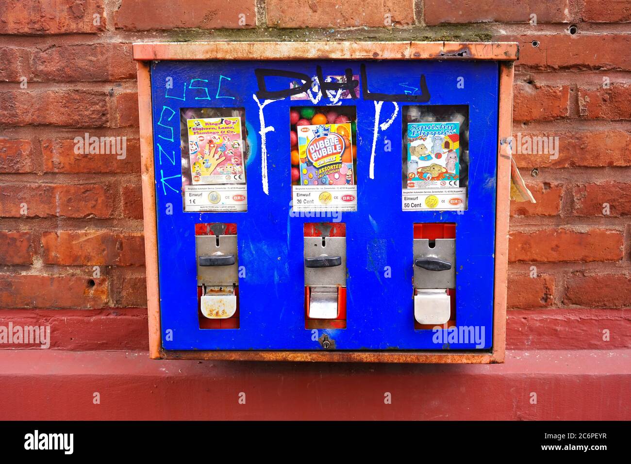 Nahaufnahme eines Retro-Kaugummi-Münzautomaten an der Wand eines Gebäudes in Deutschland. Stockfoto