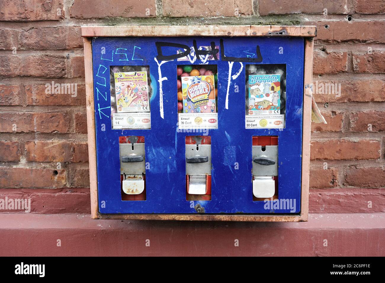 Nahaufnahme eines Retro-Kaugummi-Münzautomaten an der Wand eines Gebäudes. Retro-Filter. Stockfoto
