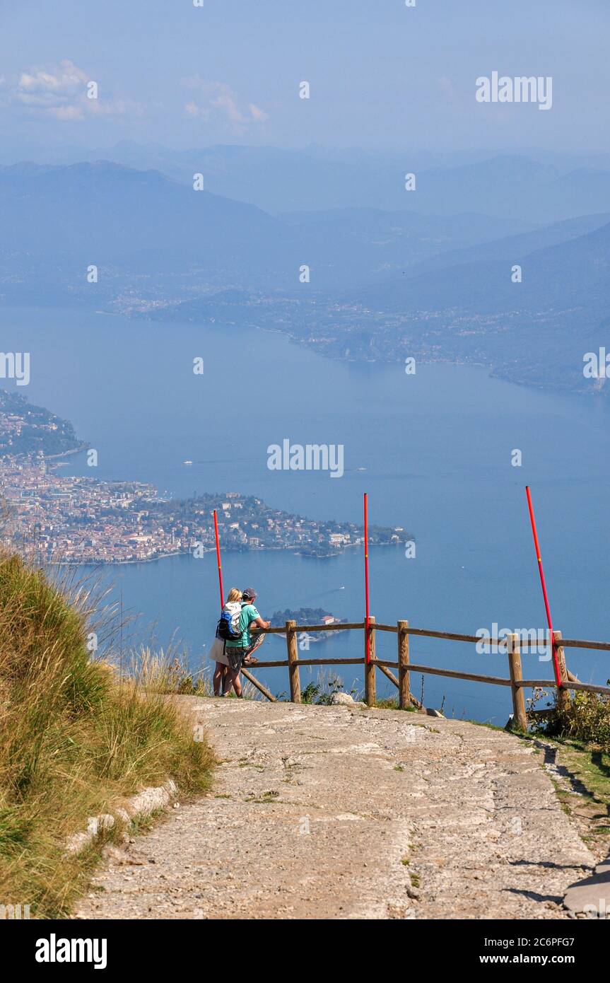 Zwei Touristen, die innehalten, um den Blick auf den Lago Maggiore von Mottarone, Italien, zu bewundern Stockfoto