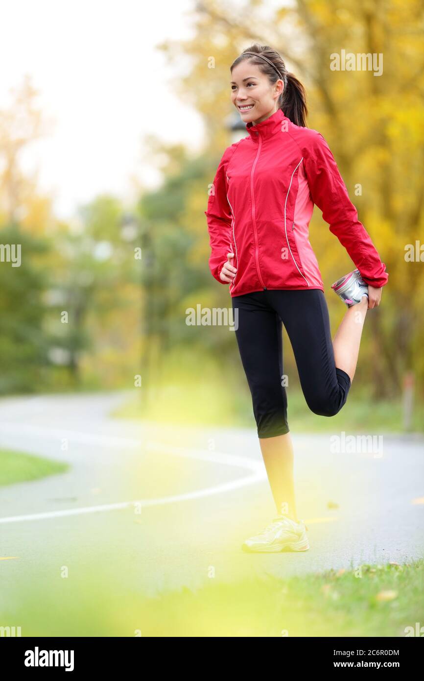Läuferin Frau dehnt Oberschenkel Stockfoto