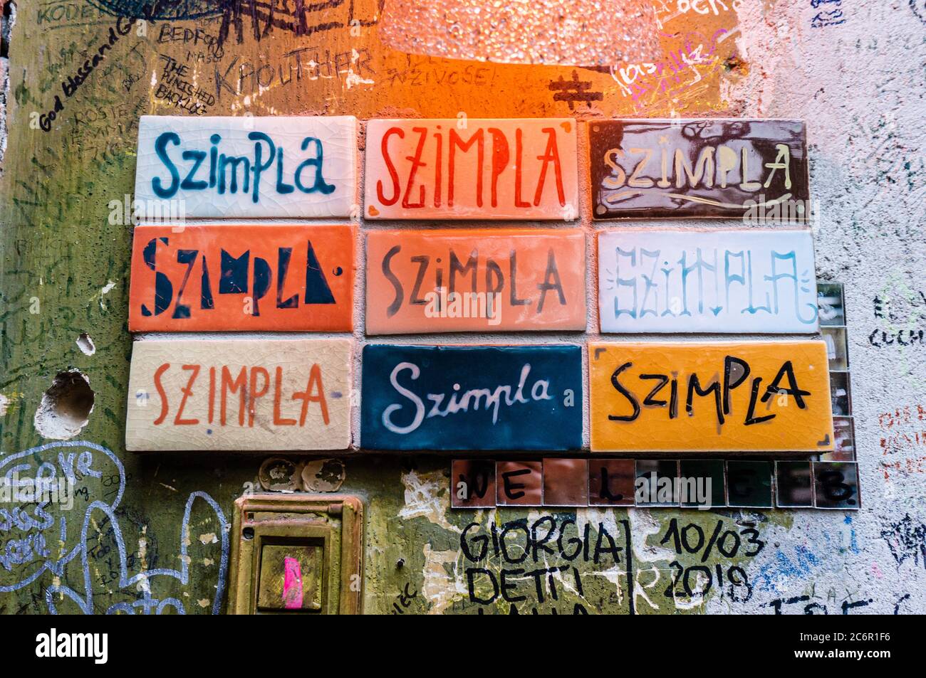 Ungarn, Budapest - 8. August 2018. Schilder mit Wort Szimpl auf bunten Fliesen geschrieben. Ruin Bar Pub romkocsma. Originalität abwechslungsreiche Schriftzüge Graffiti Stockfoto