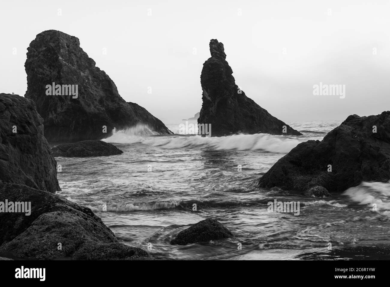 Schwarz und weiß von Wellen, die auf den Meeresstapeln am Bandon Beach in Oregon schwassen Stockfoto