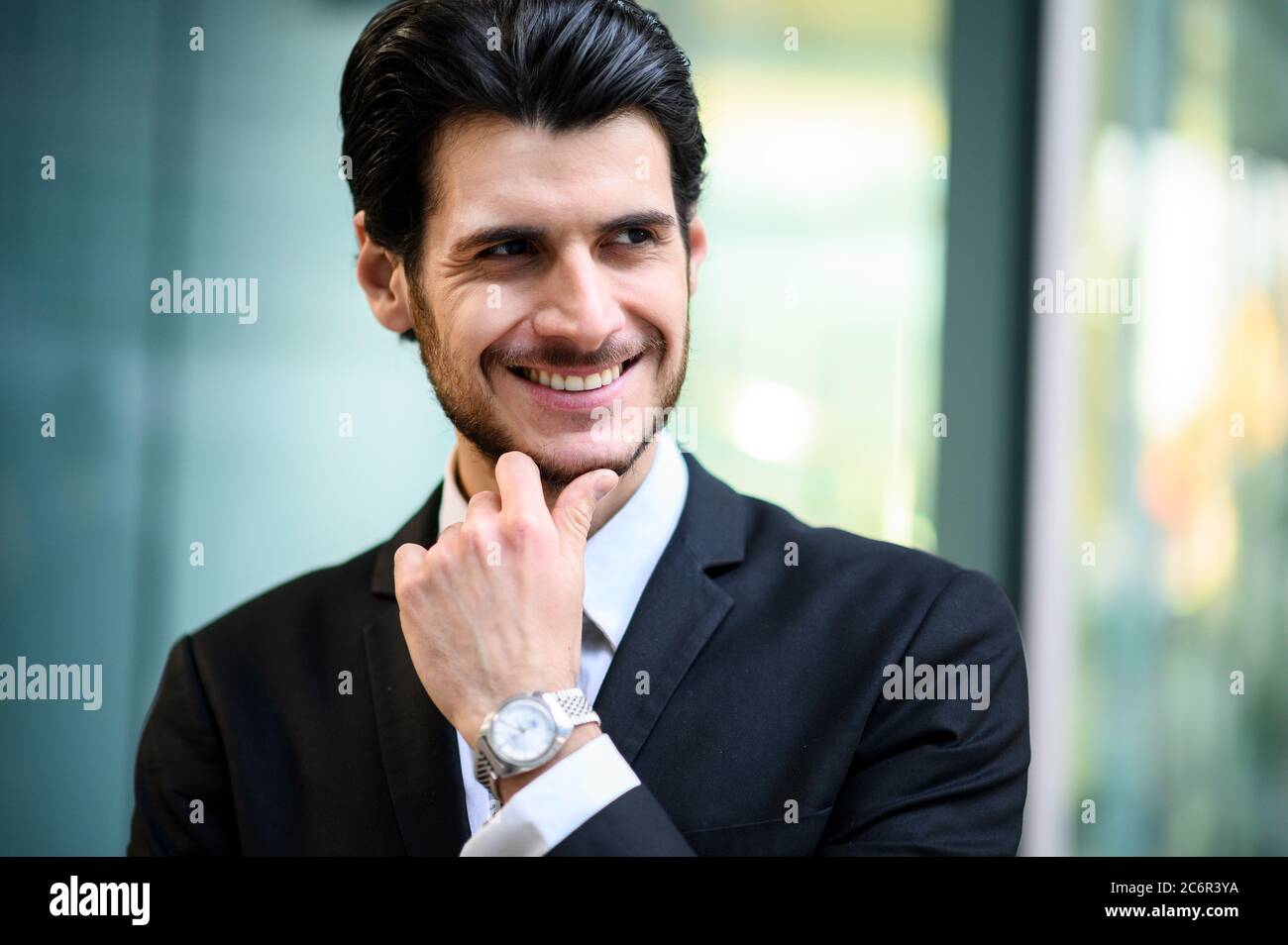 Junger Geschäftsmann im Freien lächelt selbstbewusst Stockfoto