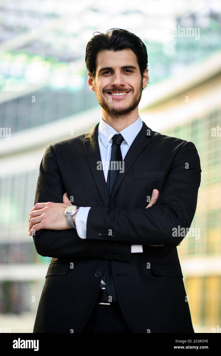 Junger Geschäftsmann im Freien lächelt selbstbewusst Stockfoto