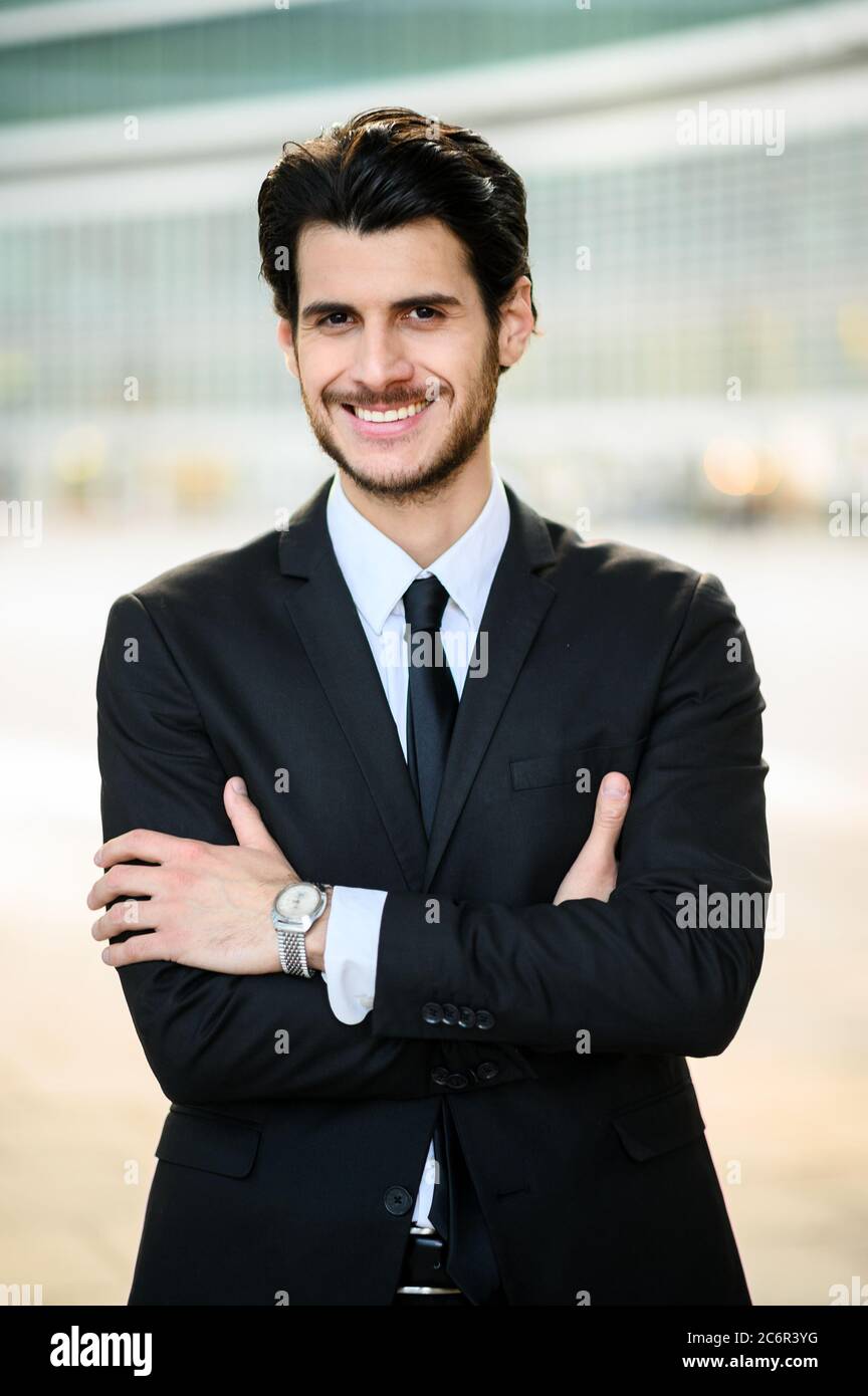 Junger Geschäftsmann im Freien lächelt selbstbewusst Stockfoto