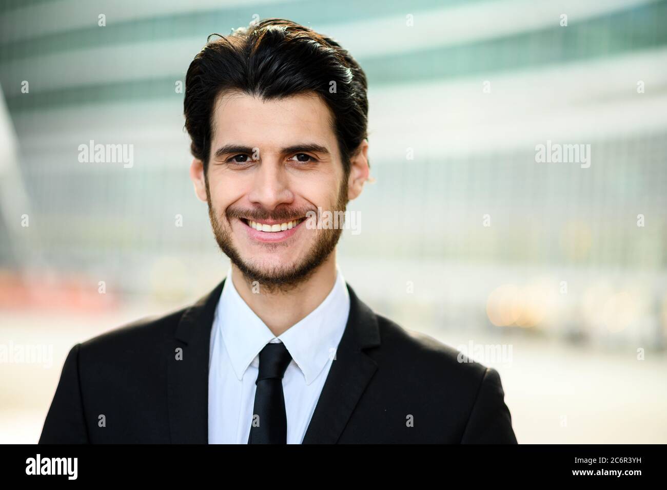 Junger Geschäftsmann im Freien lächelt selbstbewusst Stockfoto
