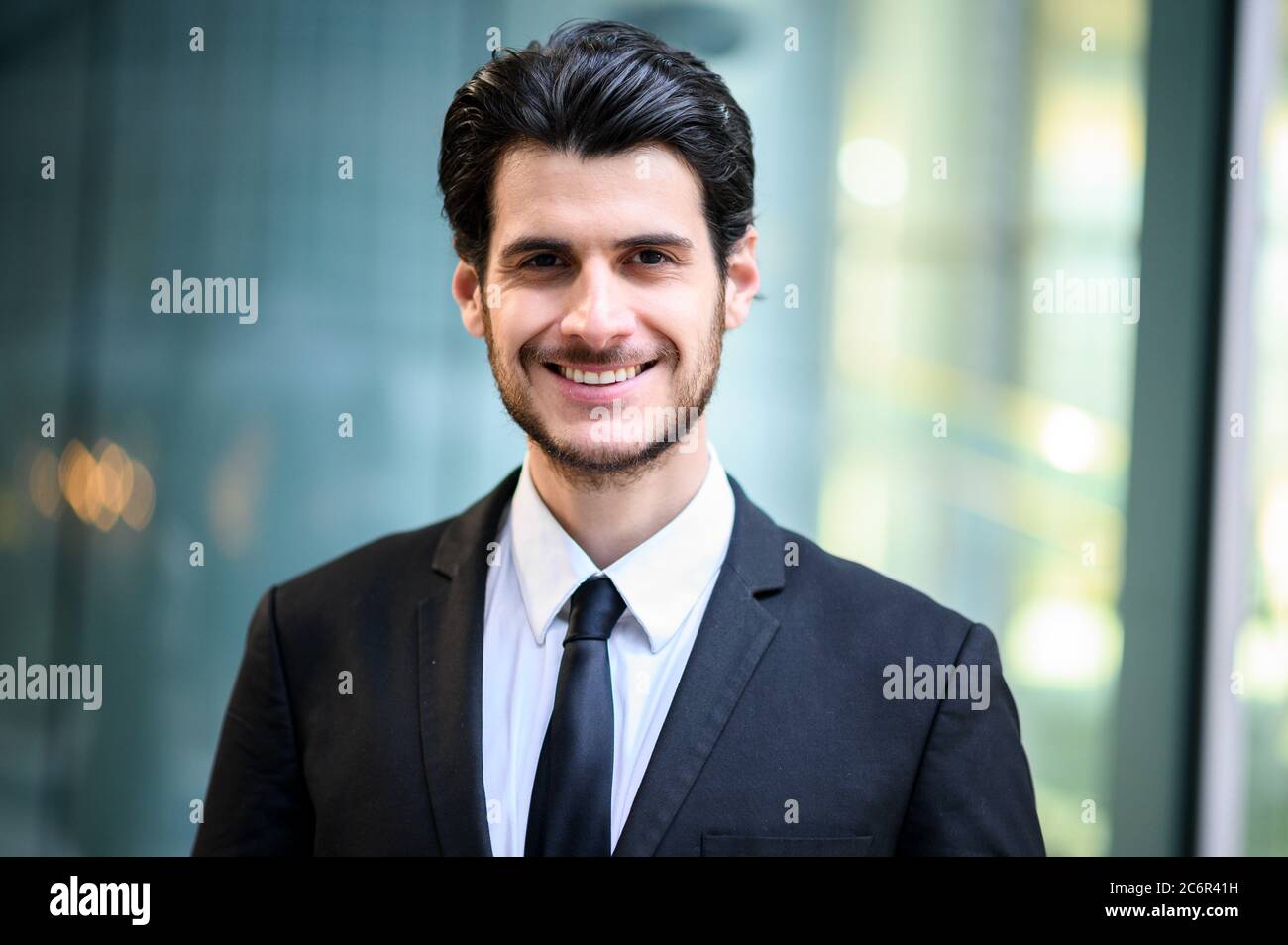 Junger Geschäftsmann im Freien lächelt selbstbewusst Stockfoto