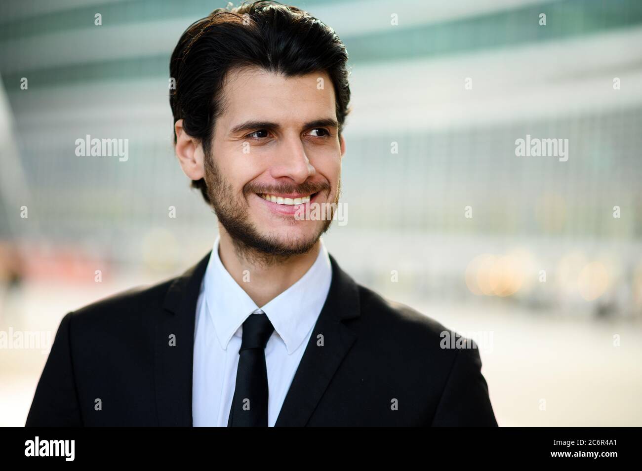 Junger Geschäftsmann im Freien lächelt selbstbewusst Stockfoto