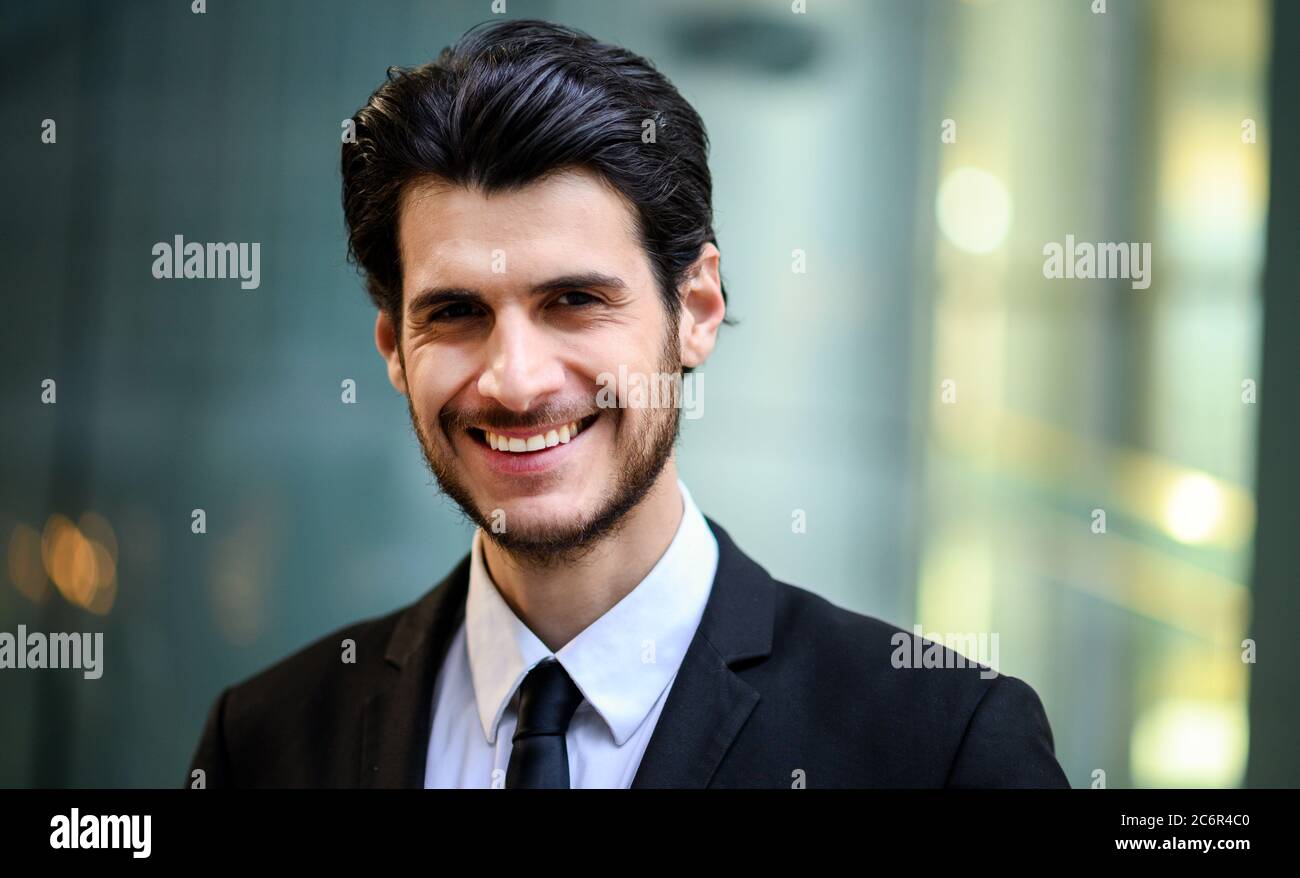 Junger Geschäftsmann im Freien lächelt selbstbewusst Stockfoto