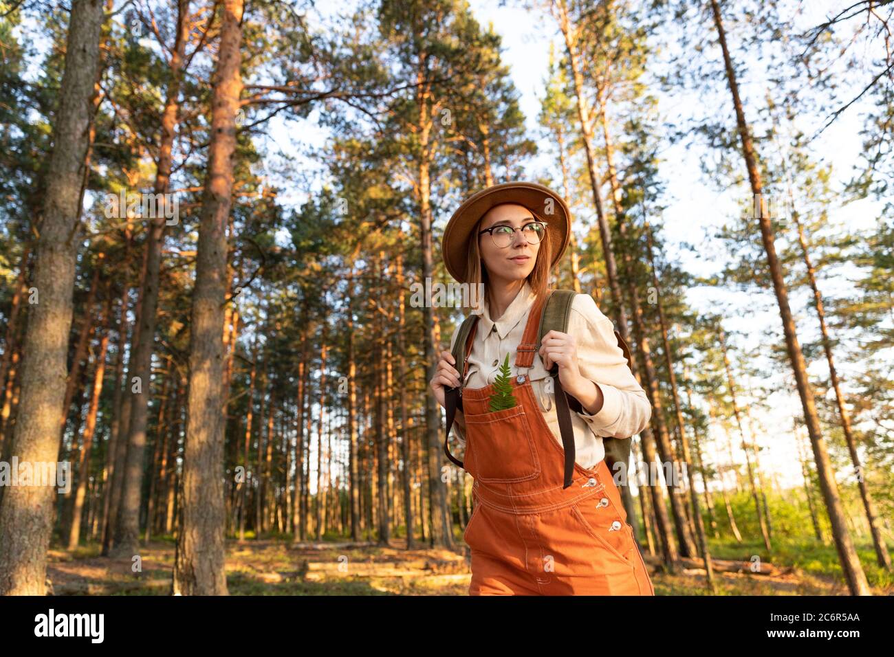 Portrait einer Botanistin mit Rucksack auf ökologischem Wanderweg im Sommer. Naturforscher erkunden Wildtiere und Ökotourismus Abenteuer Wandern in einem Wil Stockfoto