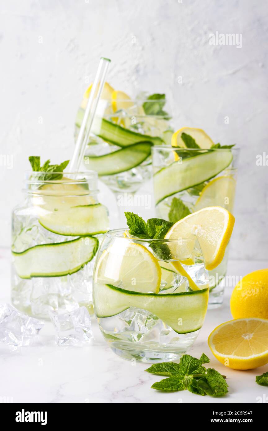 Alkoholgetränk (Gin Tonic Cocktail) mit Zitrone, Gurke, Minzblättern und Eis auf Weiß. Eisgetränk mit Zitrone. Stockfoto