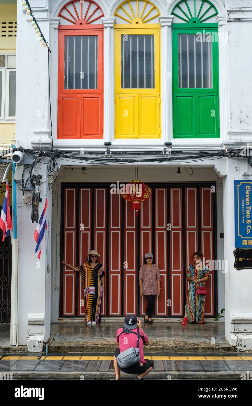 Thailändische Touristen fotografieren vor einem farbenfrohen chinesisch-portugiesischen oder peranakan-artigen Haus in Thalang Rd., Altstadt, Phuket Town, Thailand Stockfoto