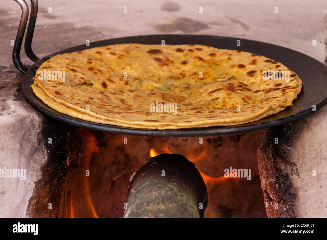 Aloo Paratha, Kochen auf dem Holz-Kaminofen (Chulha) Stockfoto
