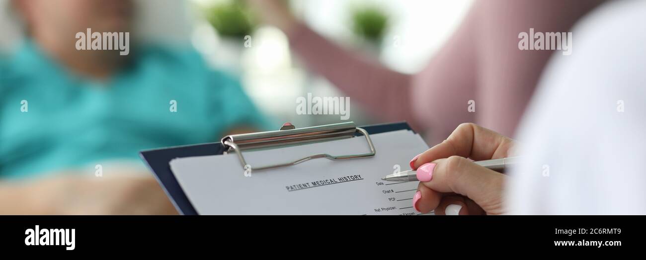 Ärztin füllt Krankenakte des Patienten aus Stockfoto