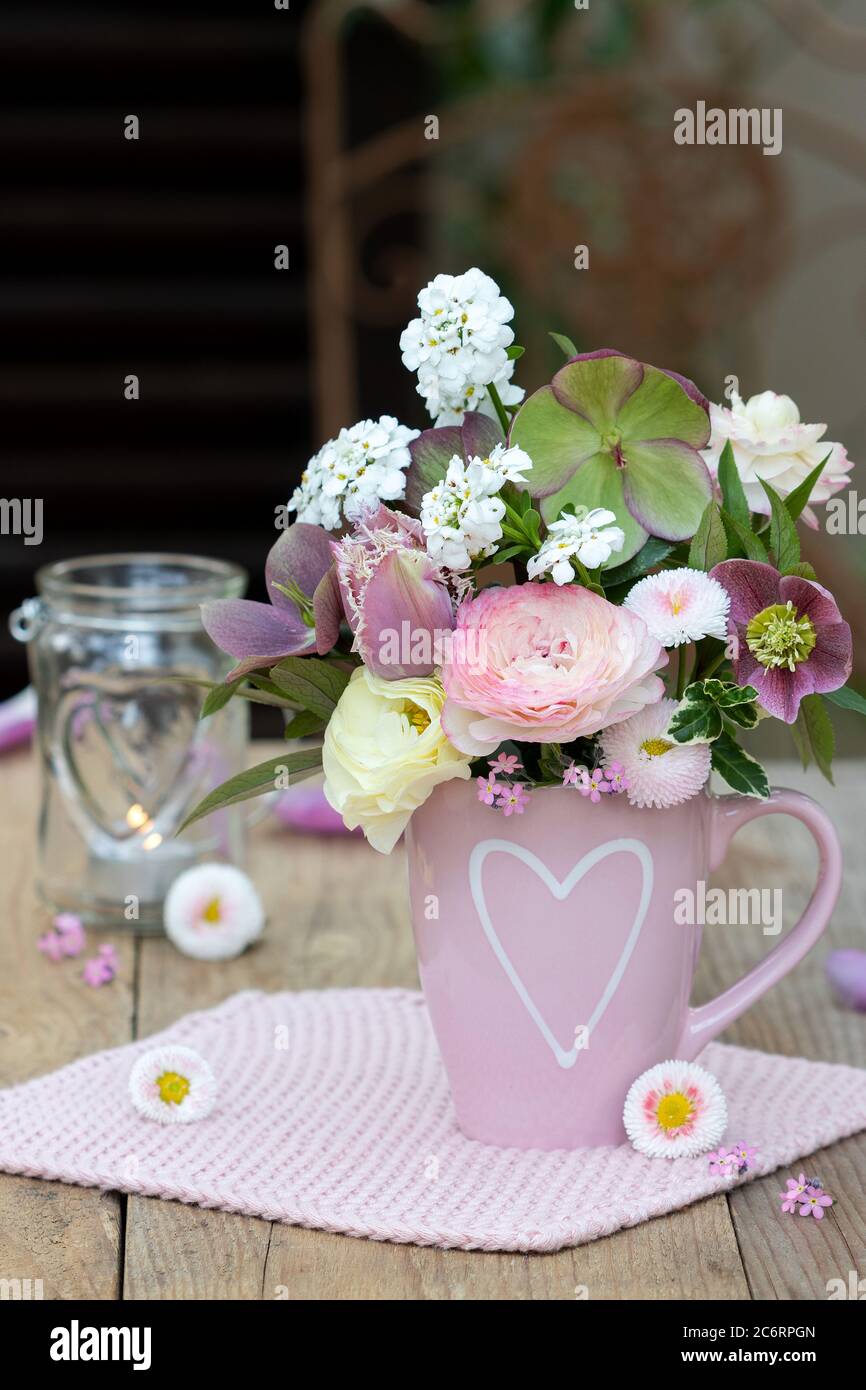 Blumenstrauß in Pastellfarben in einer Tasse mit Herz-Ornament Stockfoto