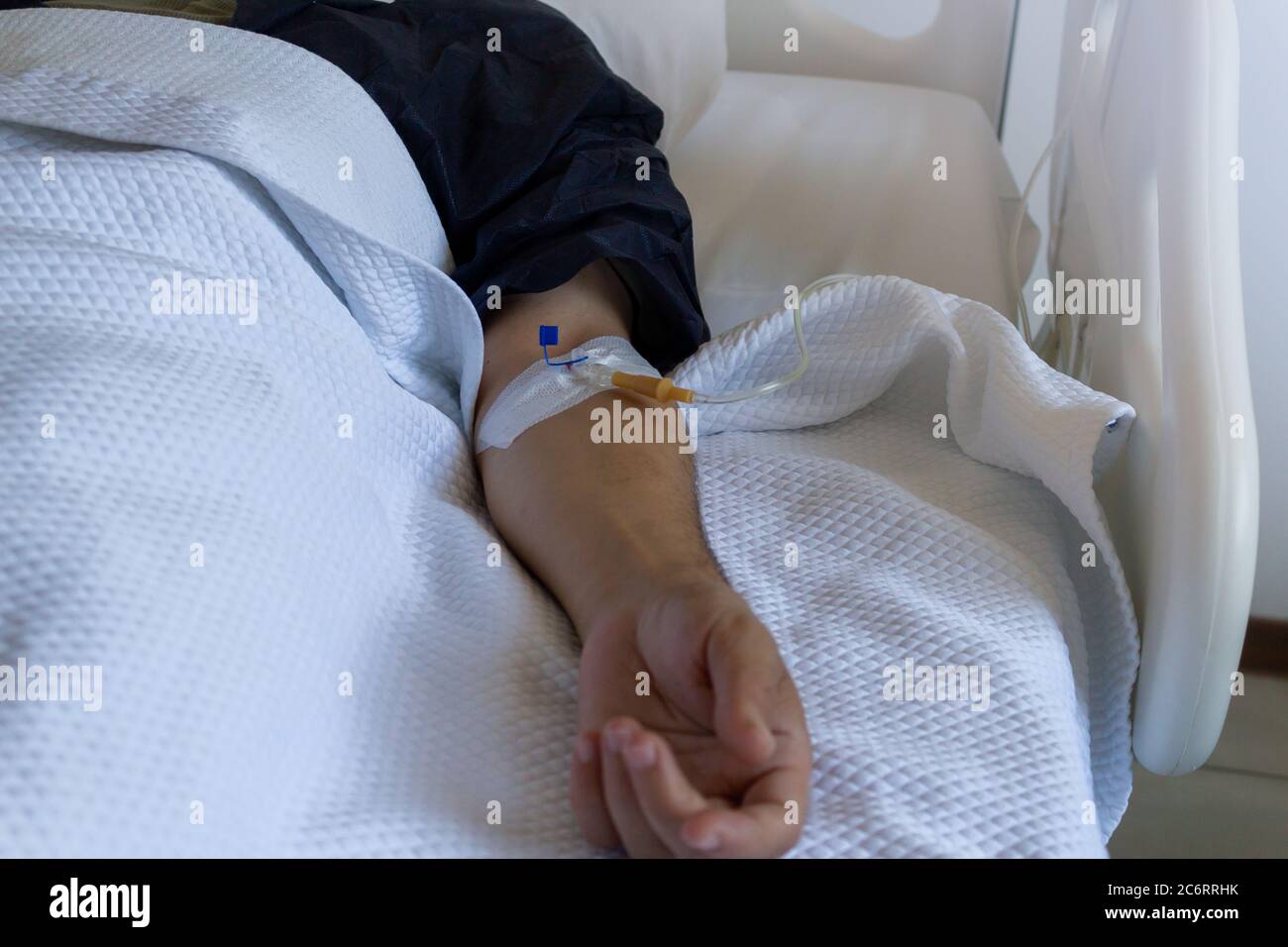 Männlicher Patient mit einem Serum im Krankenhaus Stockfoto