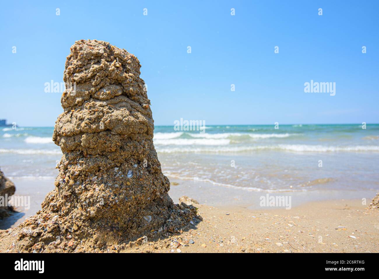 Ein Haufen nasser Sand am Meeresufer, rechts ist ein leerer Platz für die Inschrift Stockfoto