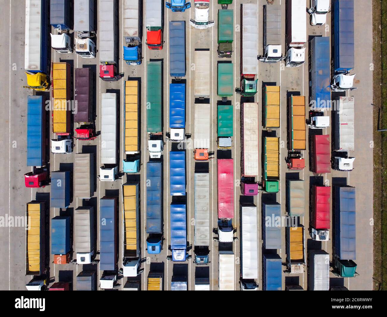 Viele Lastwagen auf dem Parkplatz, eine Warteschlange von Lastwagen zum Entladen. Draufsicht. Konzept von Transport und Logistik Stockfoto