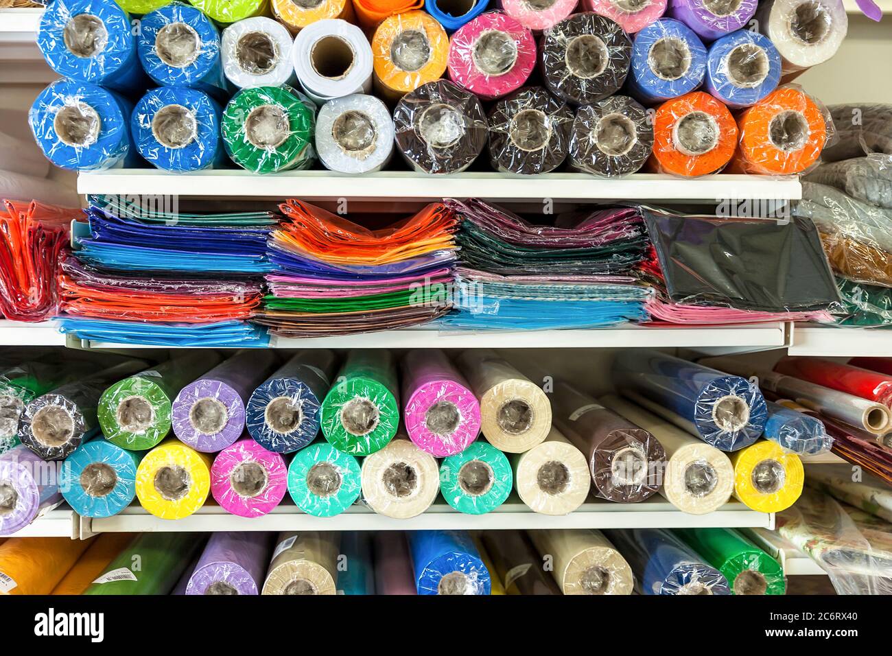 Farbiges Textilmaterial in Zellophanfolie auf dem Display. Bild Auf Lager Stockfoto