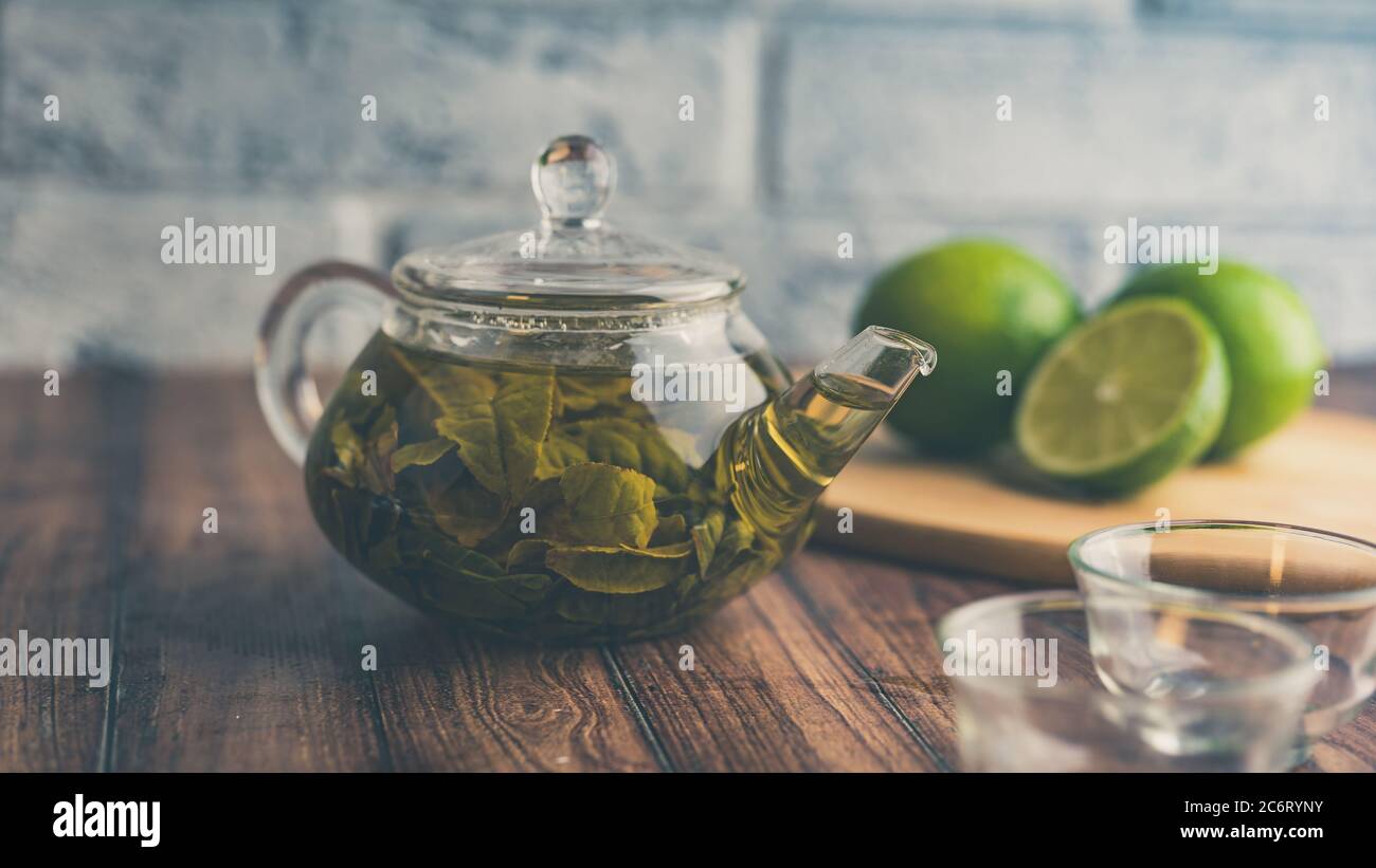 Die Teeblätter werden in kochendem Wasser gebrüht und in eine kleine Teekanne gegeben. Das Konzept der Tee-Party. Grüner Tee in einer Teekanne Stockfoto