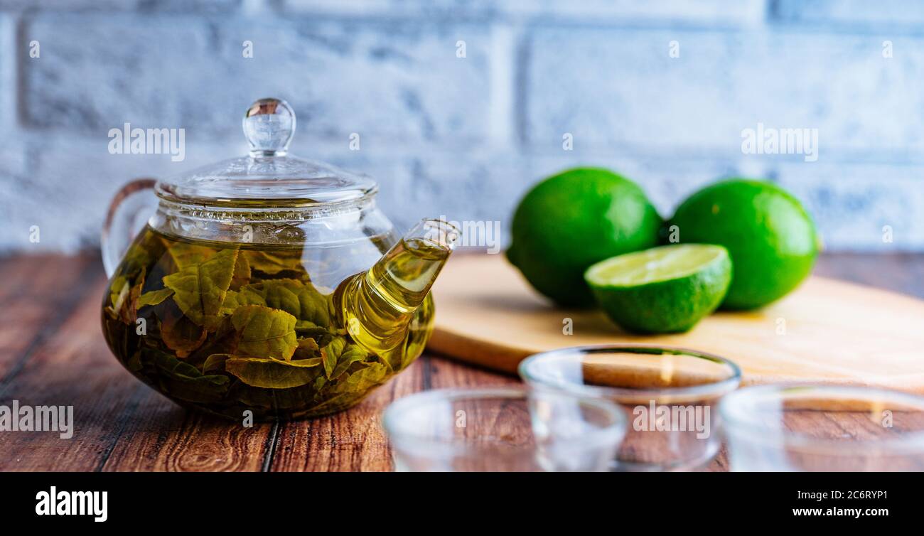 Die Teeblätter werden in kochendem Wasser gebrüht und in eine kleine Teekanne gegeben. Das Konzept der Tee-Party. Grüner Tee in einer Teekanne Stockfoto