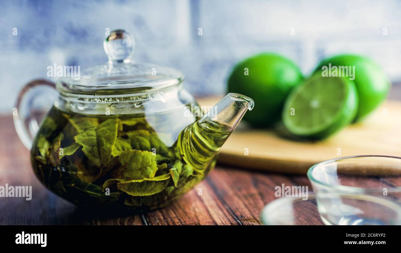 Die Teeblätter werden in kochendem Wasser gebrüht und in eine kleine Teekanne gegeben. Das Konzept der Tee-Party. Grüner Tee in einer Teekanne Stockfoto