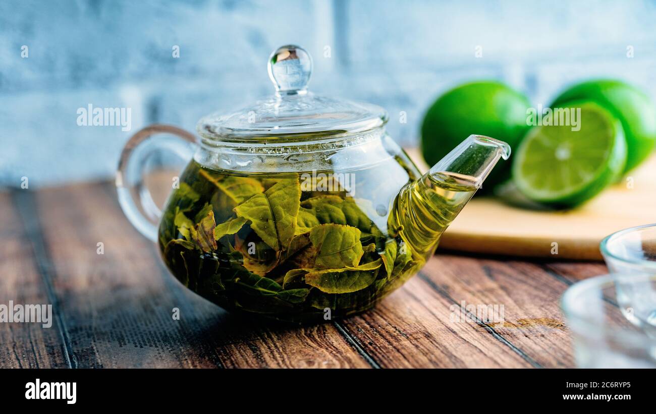 Die Teeblätter werden in kochendem Wasser gebrüht und in eine kleine Teekanne gegeben. Das Konzept der Tee-Party. Grüner Tee in einer Teekanne Stockfoto