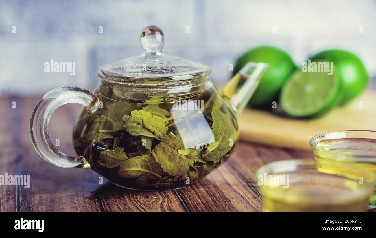 Die Teeblätter werden in kochendem Wasser gebrüht und in eine kleine Teekanne gegeben. Das Konzept der Tee-Party. Grüner Tee in einer Teekanne Stockfoto