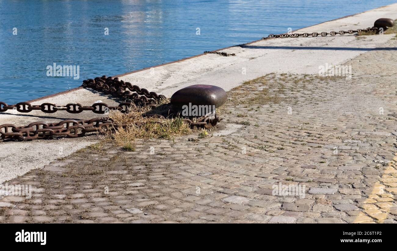 Rostiger Ankerplatz mit eiserner Kette am Hafenpier (Pesaro, Italien, Europa) Stockfoto