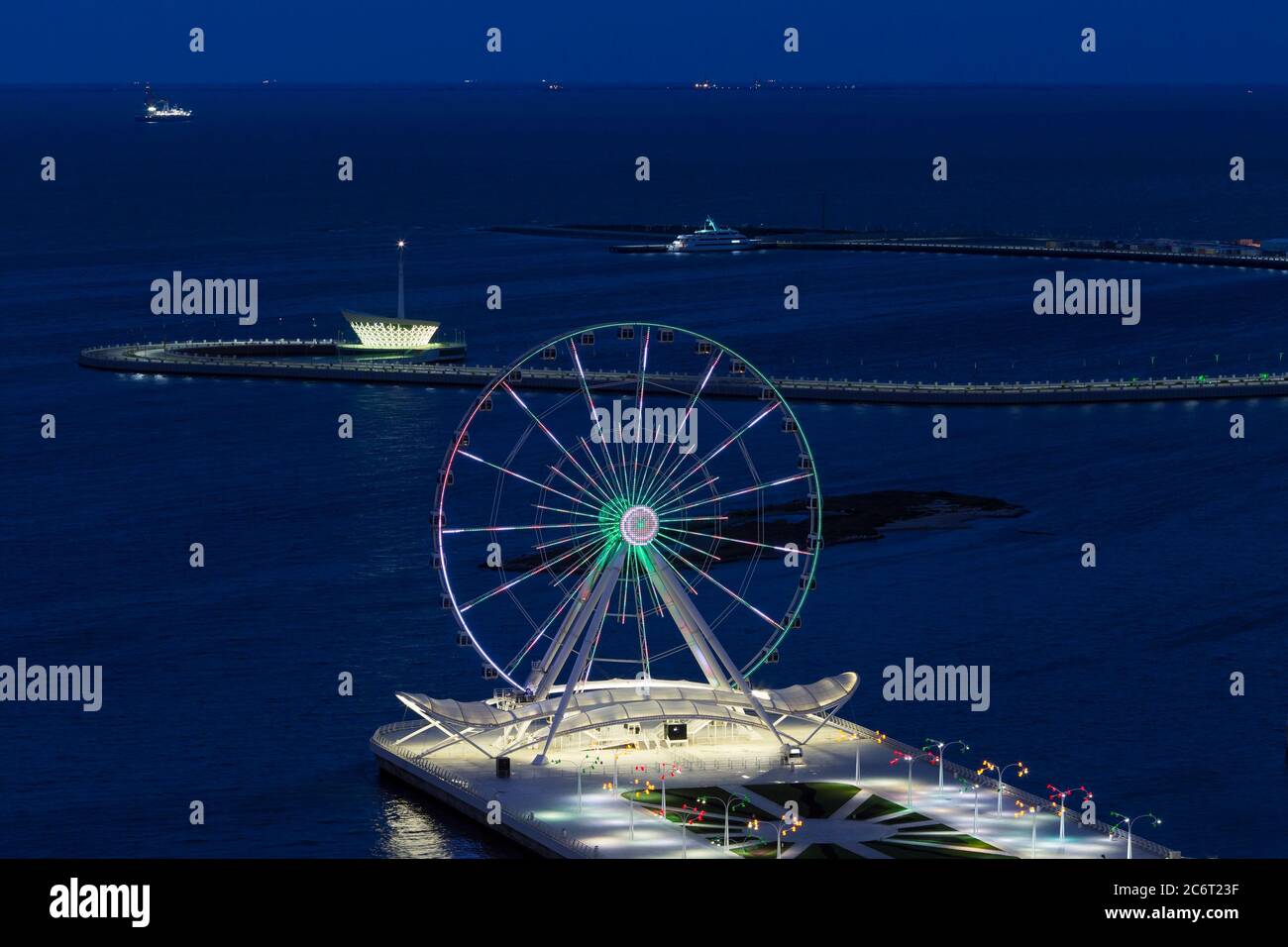 Blick über die Bucht von Baku in der Abenddämmerung mit dem Rad von Baku Eye oder Devils. Das Baku Eye ist ein Riesenrad an der Bucht von Baku in Aserbaidschan. Stockfoto