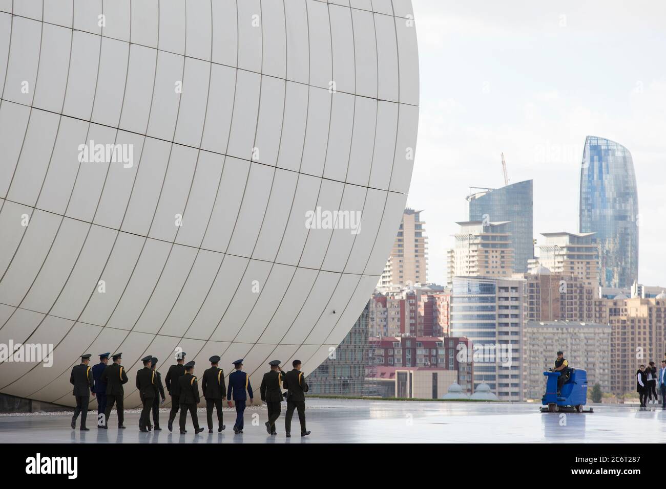 Soldaten gehen an der Front des Heydar Aliyev Zentrums vorbei, das von Zaha Hadid entworfen wurde und das Herzstück der modernen Architektur in Baku Aserbaidschan ist Stockfoto
