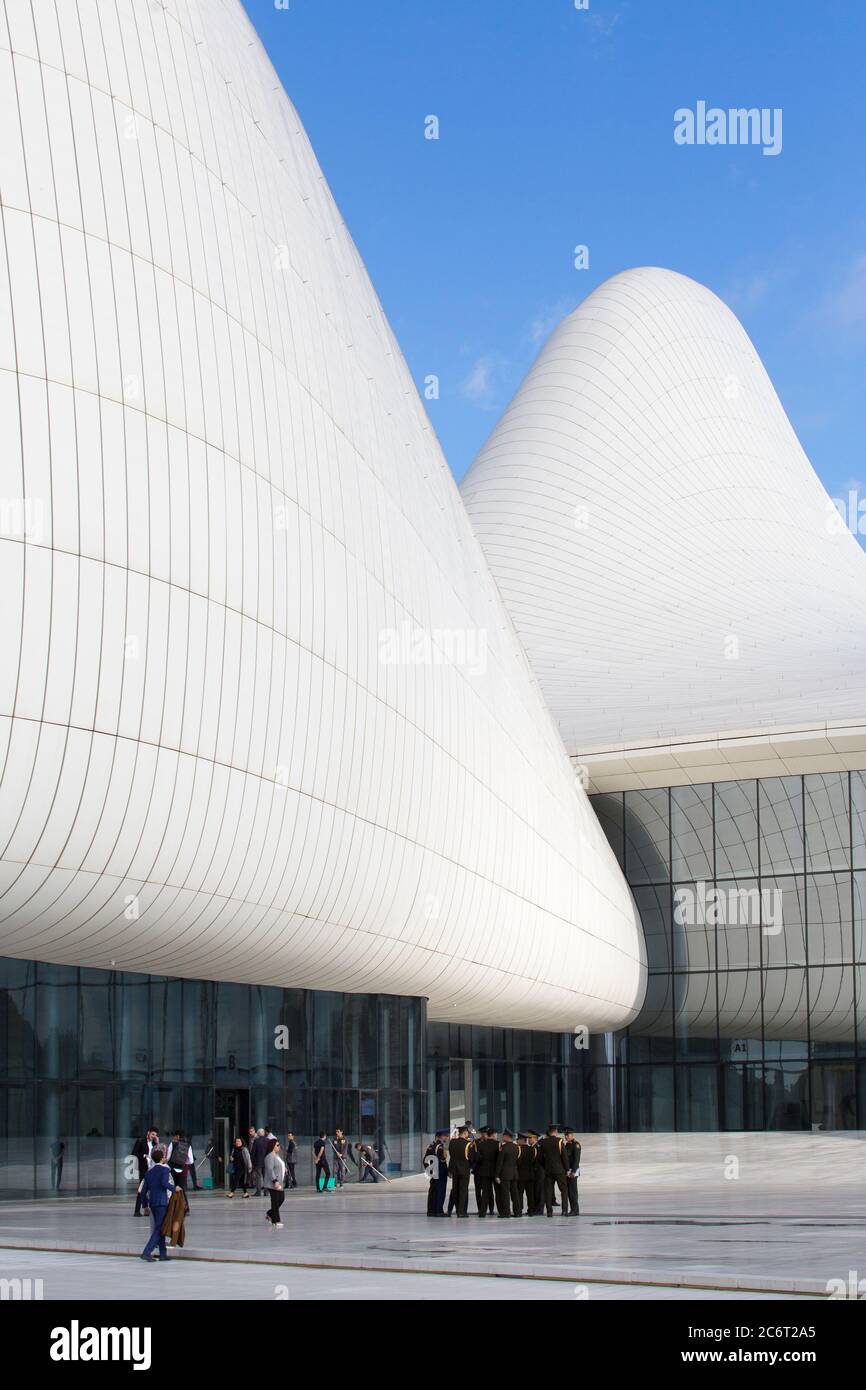 Soldaten gehen an der Front des Heydar Aliyev Zentrums vorbei, das von Zaha Hadid entworfen wurde und das Herzstück der modernen Architektur in Baku Aserbaidschan ist Stockfoto