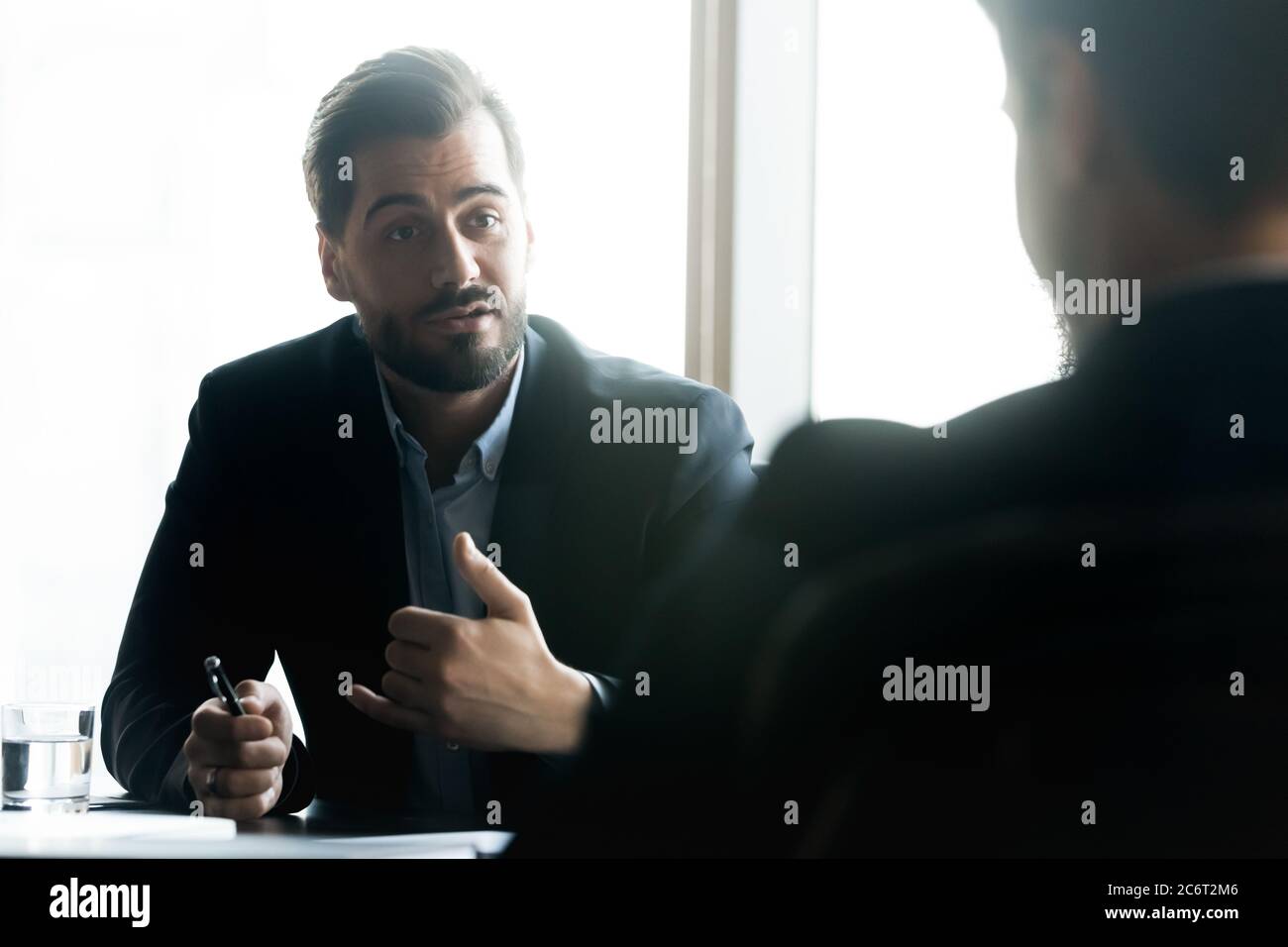 30er Geschäftsmann diskutieren Zusammenarbeit mit männlichen Partner. Stockfoto