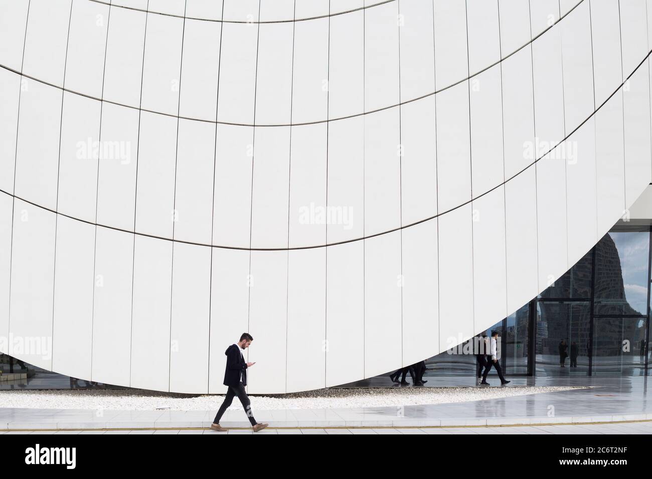 Die aserbaidschanischen Menschen gehen durch das Heydar Aliyev Zentrum, das von Zaha Hadid entworfen wurde, dem Herzstück der modernen Architektur in Baku Aserbaidschan Stockfoto