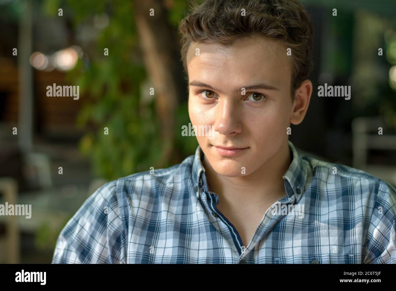 Porträt eines lächelnden jungen Mannes in einem Park Stockfoto
