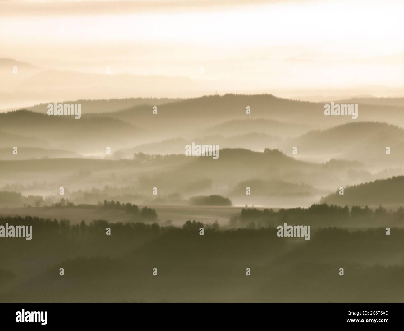 Die Sonne scheint gegen den weißen Nebel, der über dem Hügel schwebt. Stockfoto Die Sonne scheint gegen den weißen Nebel, der über dem Hügel schwebt. Stockfoto