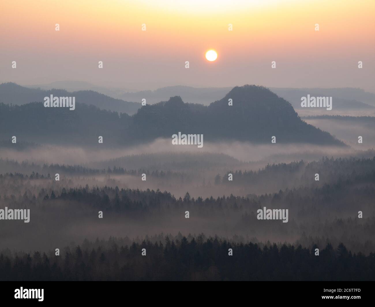 Die Sonne scheint gegen den weißen Nebel, der über dem Hügel schwebt. Stockfoto Die Sonne scheint gegen den weißen Nebel, der über dem Hügel schwebt. Stockfoto