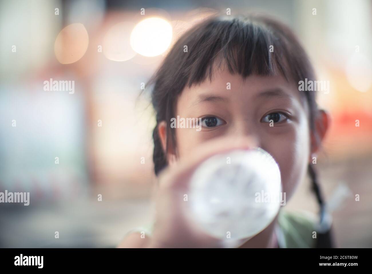 Asiatische Kind Mädchen trinken eine Flasche Wasser mit Lächeln und glücklich Stockfoto
