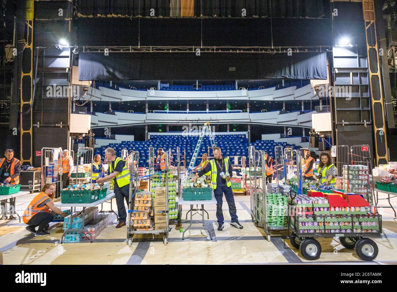 Mitglieder des Highland Council packen Tausende von Lebensmittelpaketen mit Vorräten für Highlander, die noch immer vor der Coronavirus-Pandemie auf der Bühne im Empire Theatre im Eden Court in Inverness schützen. Stockfoto