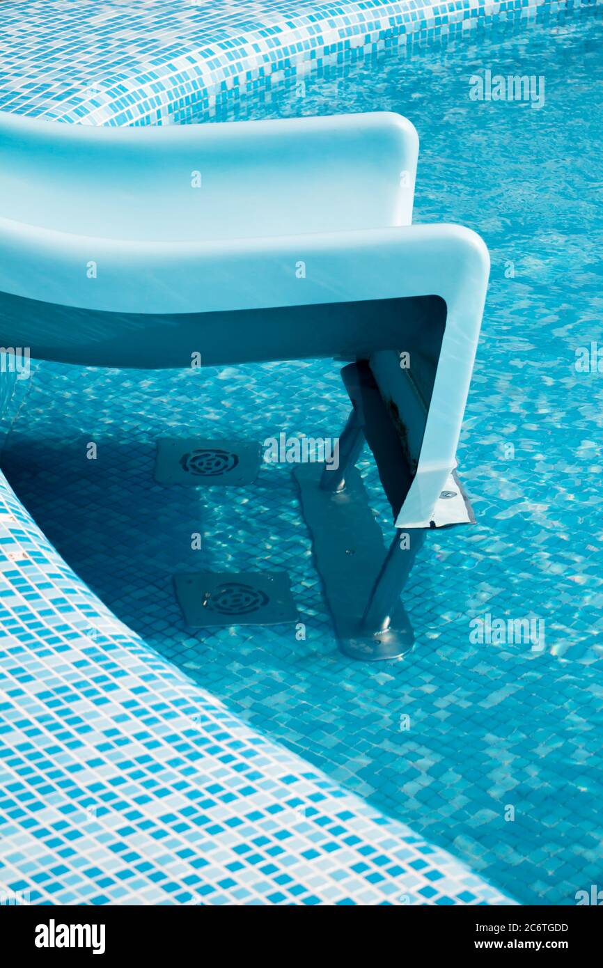 Blaues Schwimmbad mit Wasserrutsche an einem schönen und sonnigen Sommernachmittag für Hintergrund, hohe Auflösung Stockfoto