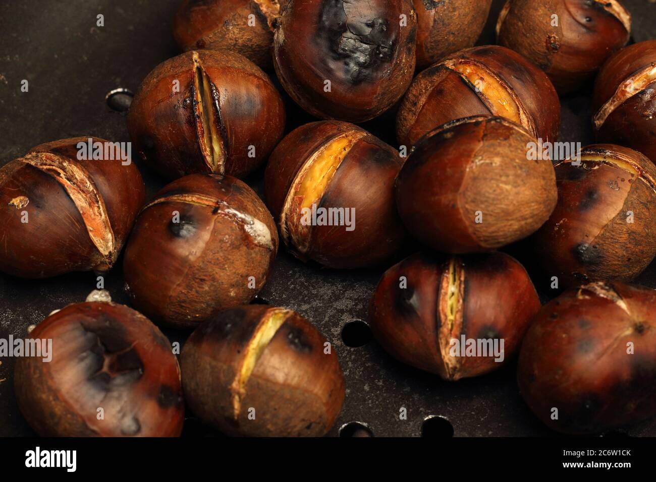 Geröstete Kastanien auf einer gebohrten Pfanne, Nahaufnahme. Stockfoto