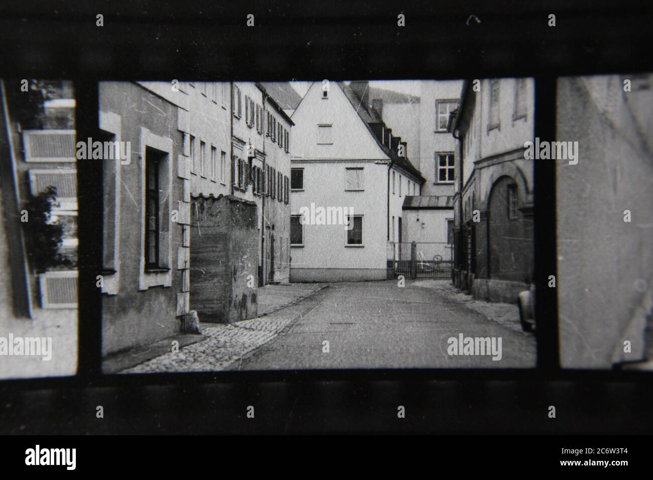 Feine 70er Jahre Vintage Kontakt Print schwarz-weiß Fotografie einer regelmäßigen Seitenstraße mit lokalen Unternehmen gesäumt. Stockfoto