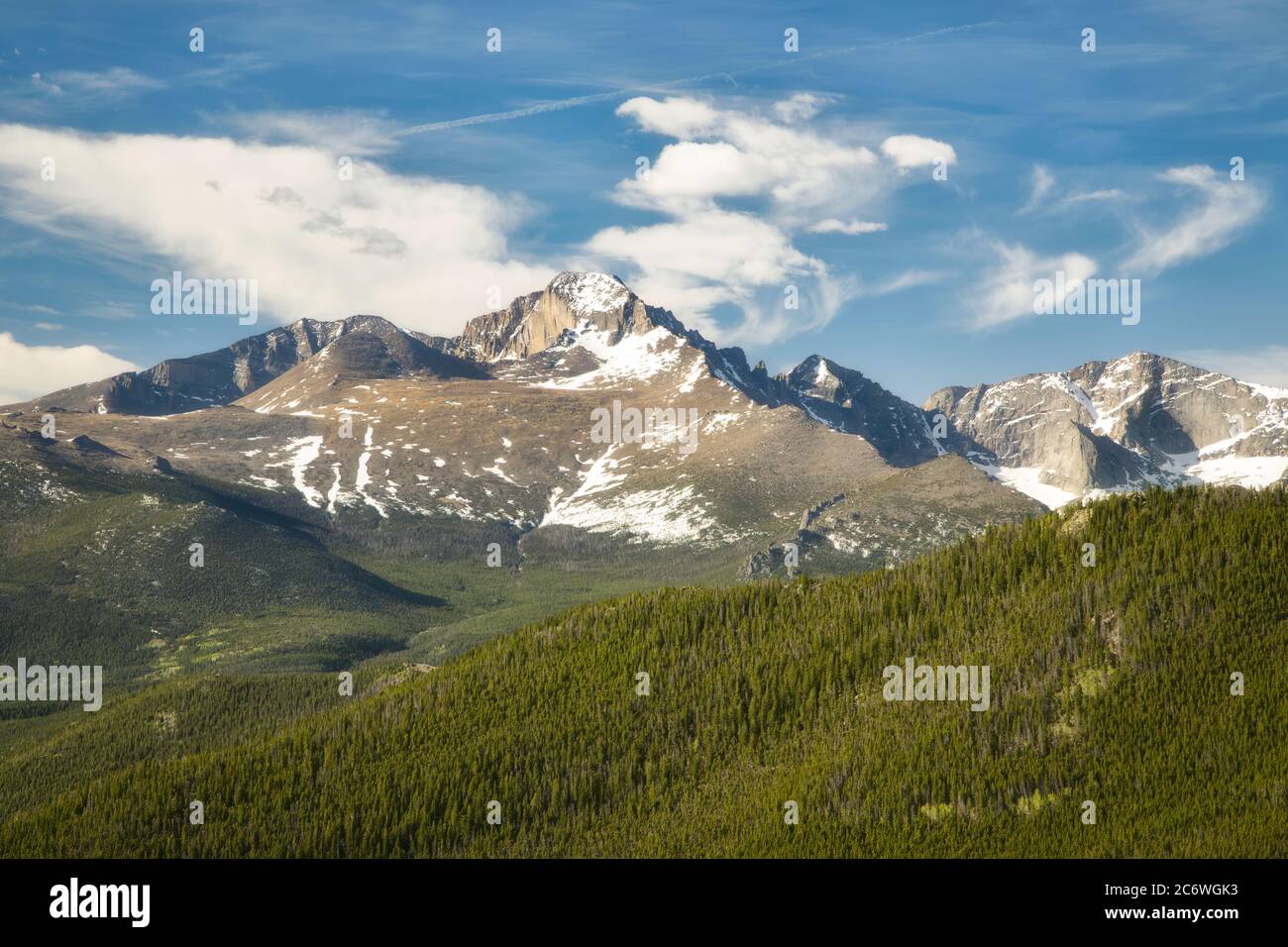 Weiße Puffy Wolken Swirlen Sie an einem Sommertag über den Peak of Longs Peak im Rocky Mountain National Park Stockfoto