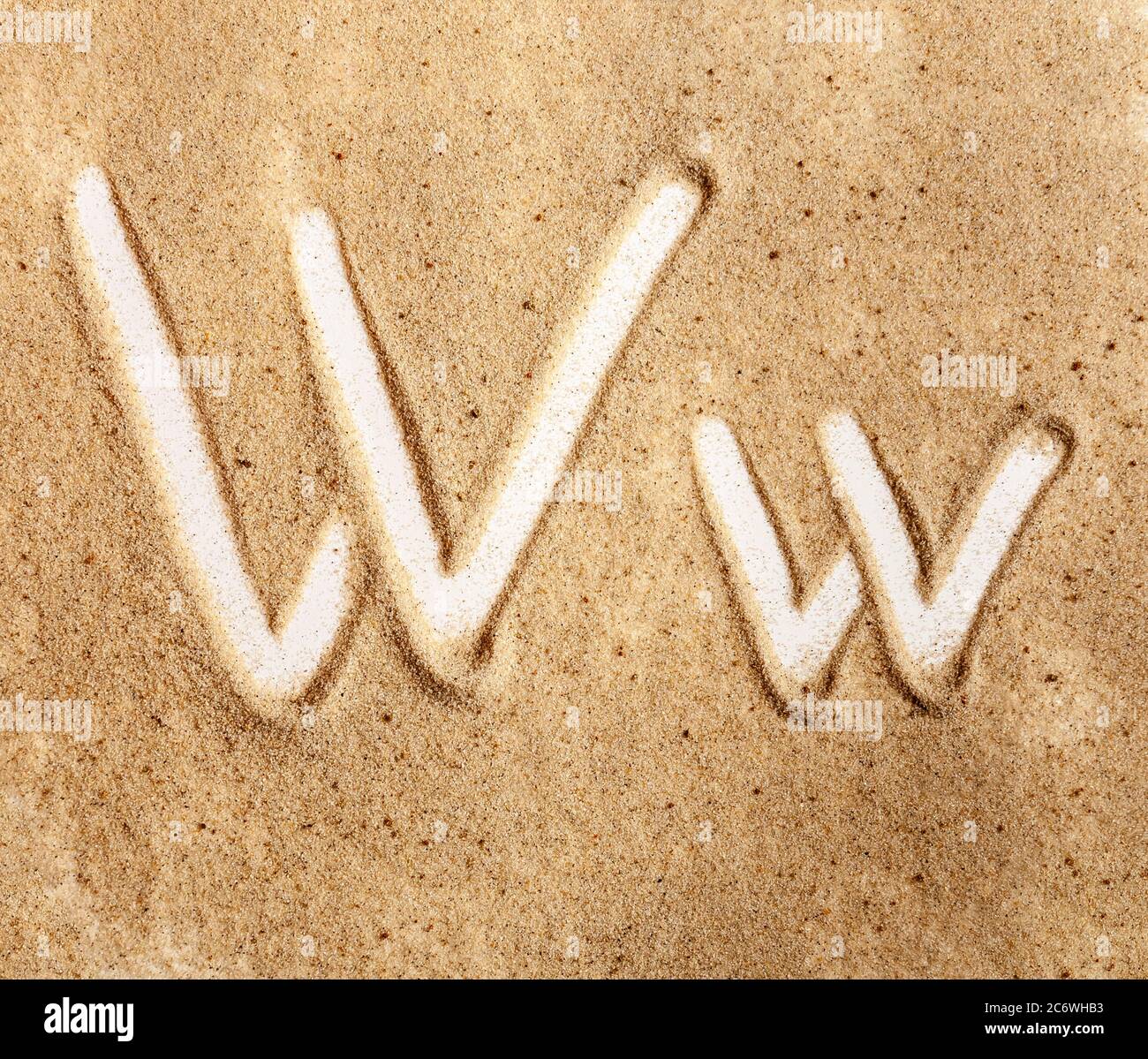Brief W. Englisches handgeschriebenes Alphabet im Sand. Stockfoto