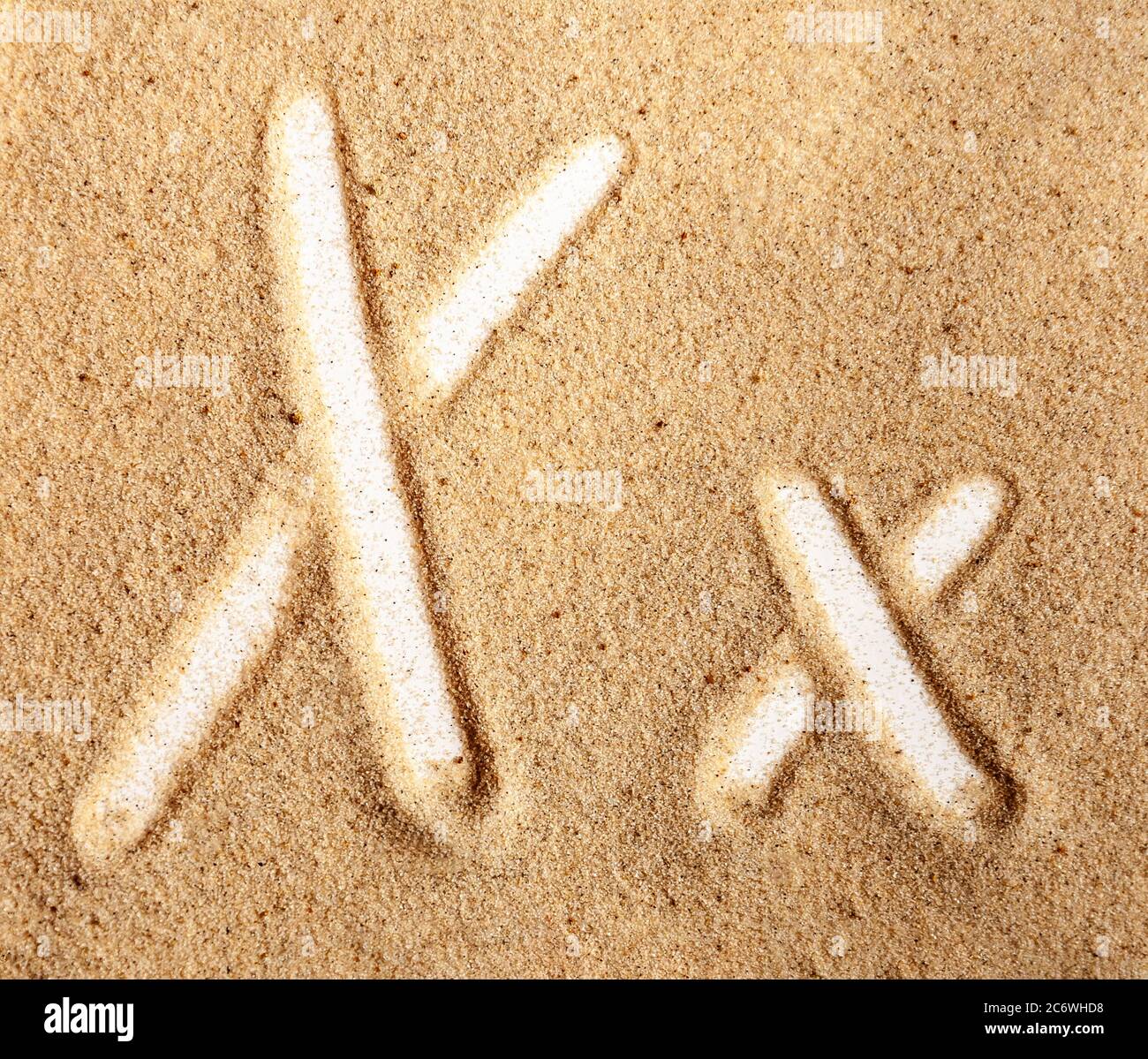 Buchstabe X. Englisches handgeschriebenes Alphabet im Sand. Stockfoto