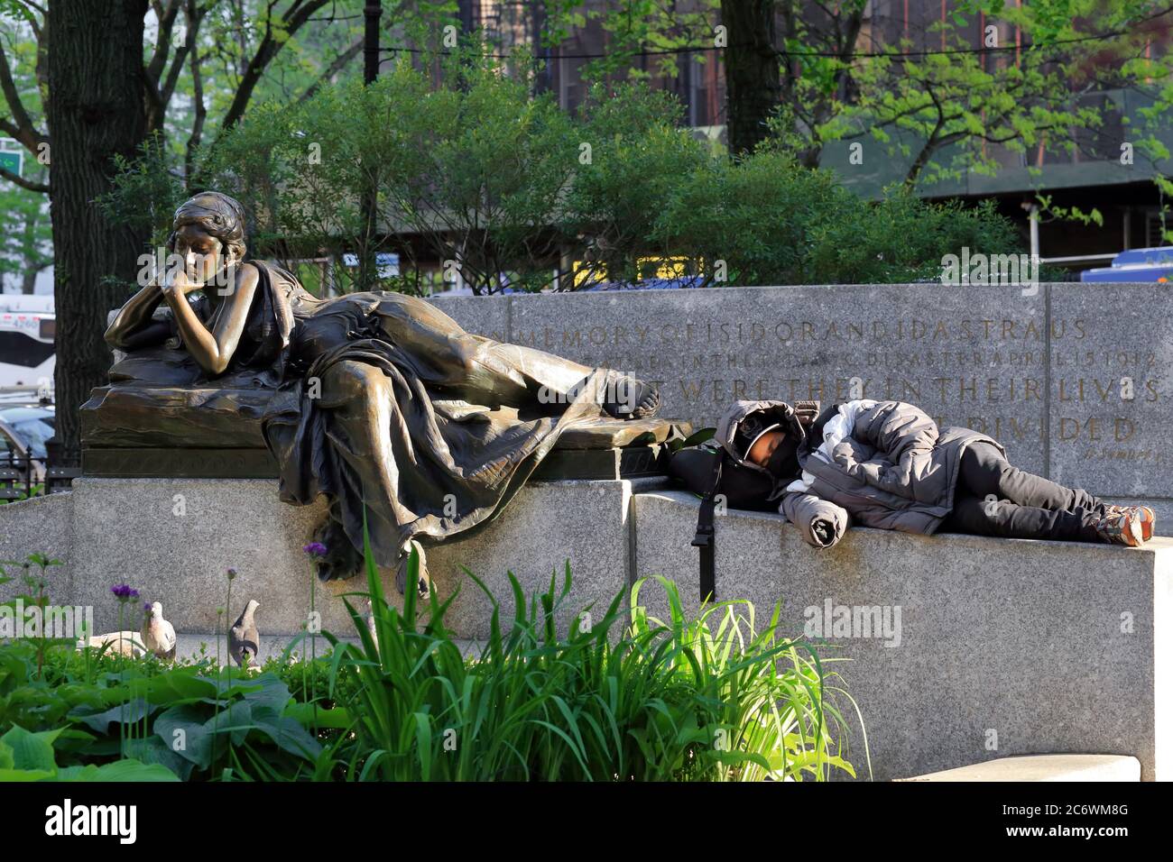Ein Mensch nippt am Fuße der Bronzestatue "Memory" des Bildhauers Augustus Lukeman im Straus Park in der Upper West Side von Manhattan, New York. Stockfoto
