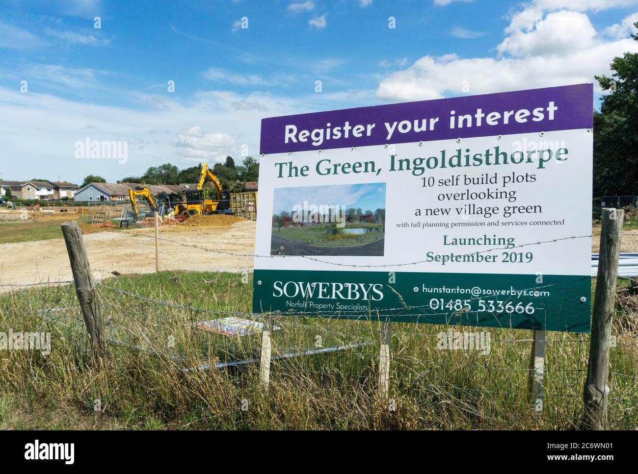 Immobilienmakler Zeichen für selbst bauen Wohngrundstücke zum Verkauf in einer Neuentwicklung rund um ein Dorf grün in Ingoldisthorpe, West Norfolk. Stockfoto